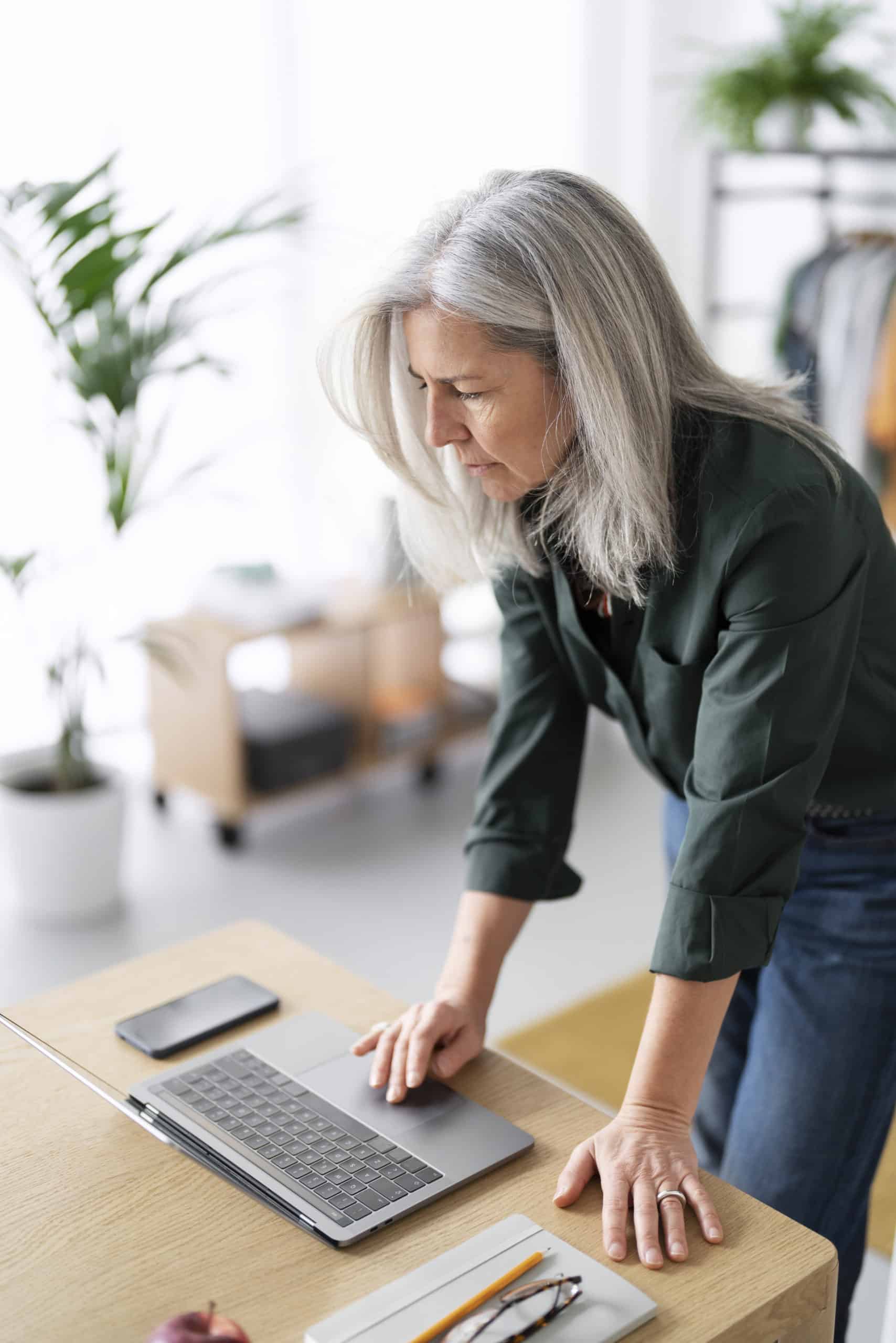 medium shot old woman working laptop scaled